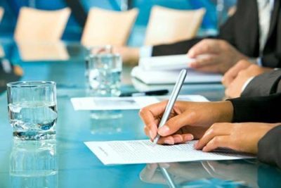 Closeup of hands signing a document with a pen