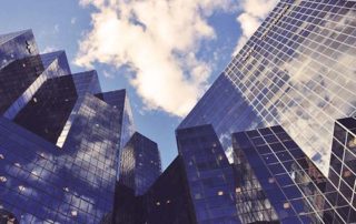 Upward perspective view of tall glass office buildlings